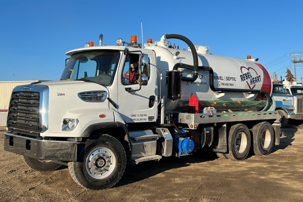 White vacuum tanker truck with orange beacon lights